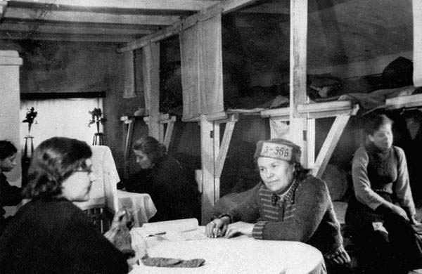 В бараке с двойными нарами. Заключенная с номером или биркой на головном уборе по неутвержденным данным эстонская Свидетельница Хельми Леэк. (архив РИА Новости)